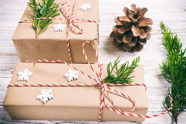 Christmas composition background Christmas gift with pine cones and fir branches on wooden background Flat lay top view copy space Toned