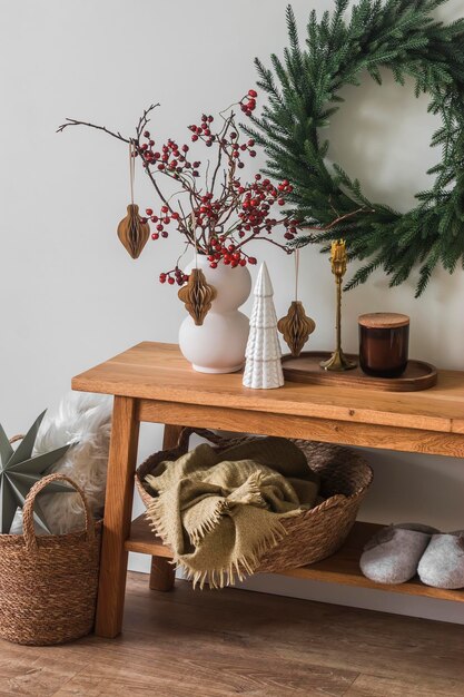 Photo christmas composition bench with christmas decor candles basket with blankets christmas tree wreath on the wall cozy christmas home