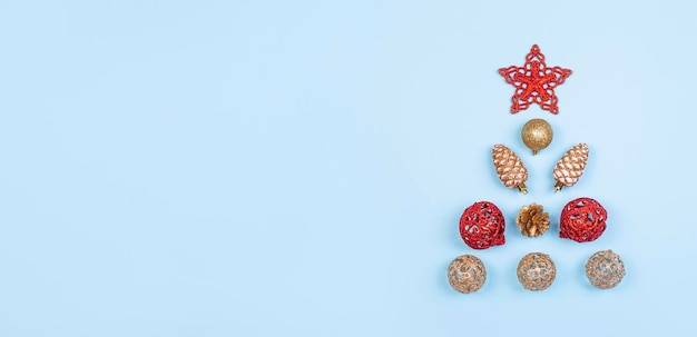 Christmas composition Christmas balls of red and gold color golden cones red decorations on a light blue background Christmas winter new year concept Flat lay top view copy space