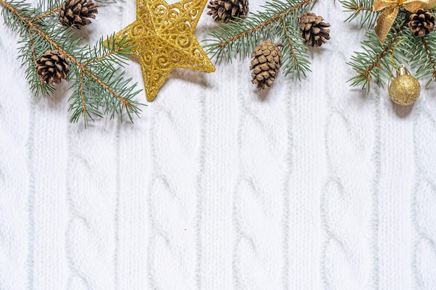 Christmas composition Christmas gift knitted blanket pine cones fir branches on wooden white background Flat lay top view copy space