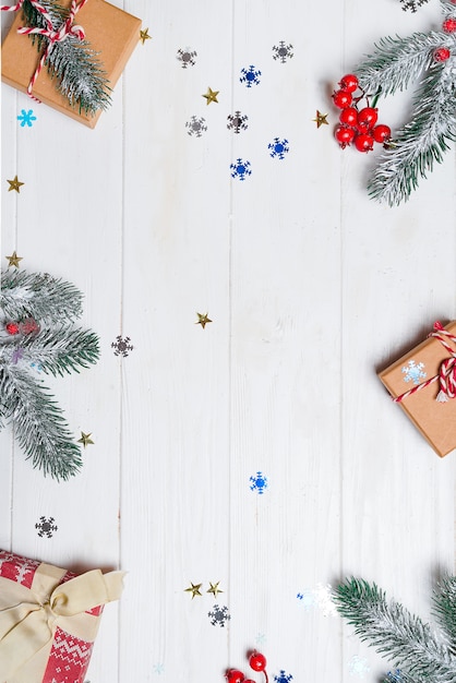 Christmas composition. Christmas gift, pine cones, fir branches on wooden white background