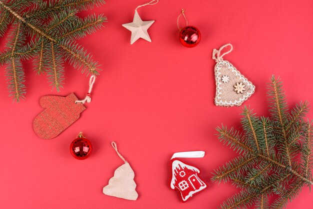 Christmas composition. Christmas red decorations, fir tree branches on red background