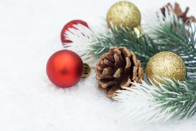 Christmas composition of christmas tree toy red and gold ball snow background tree branch cone