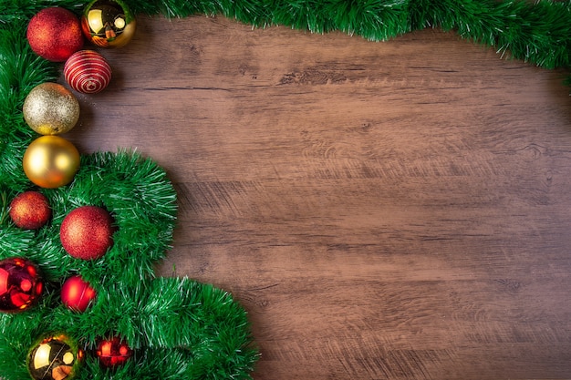 Christmas composition Decorations with red and gold Christmas balls on wooden background Top view copy space