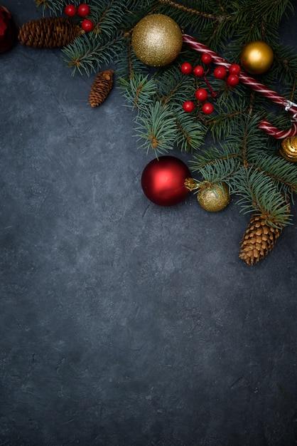 Christmas composition of fir branches, Christmas balls of red and gold and candy, pine cones.