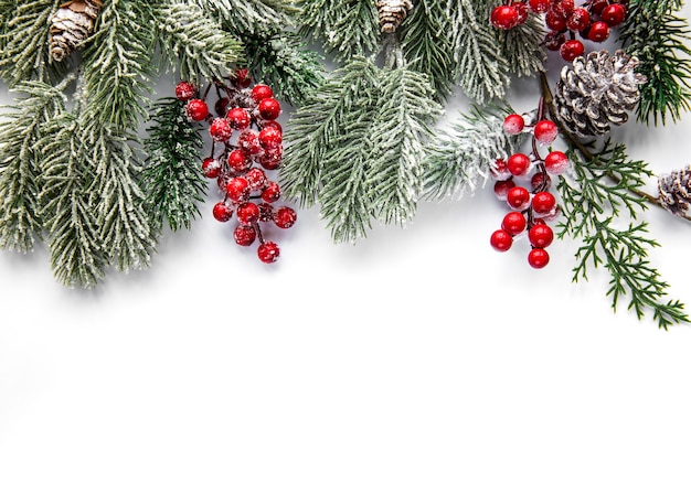 Christmas composition. Fir tree branches, red decorations on white