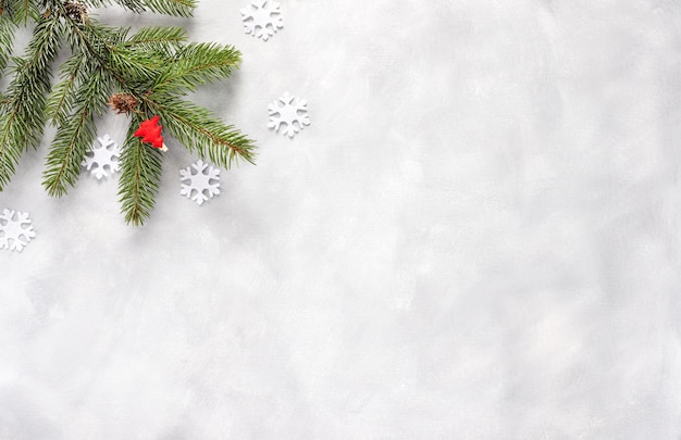 Christmas composition. Fir tree branches with red decorations and snowflake on white background. New year frame banner. Flat lay, top view, copy space