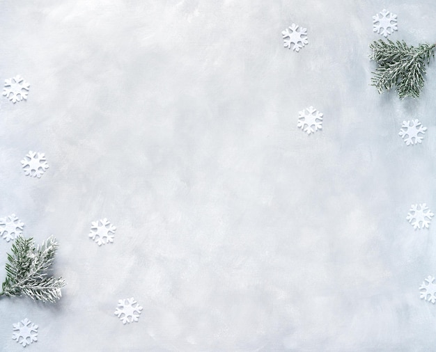 Christmas composition. Fir tree branches with snowflake on grey background. New year frame banner. Flat lay, top view, copy space