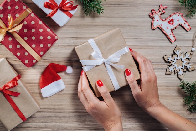 Christmas composition of gift boxes, pine tree branches and gift boxes on wooden table