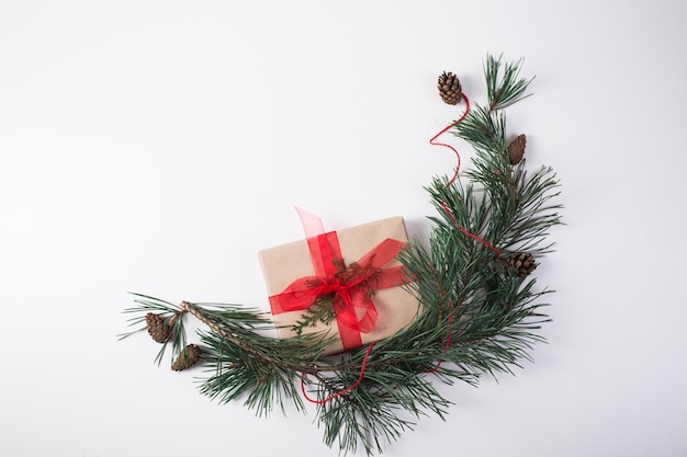 Christmas composition. Gift, christmas decoration, cypress branches, pine cones on white background