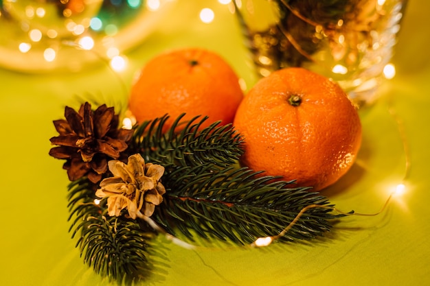 Christmas composition of a glass vase pine twigs and tangerine