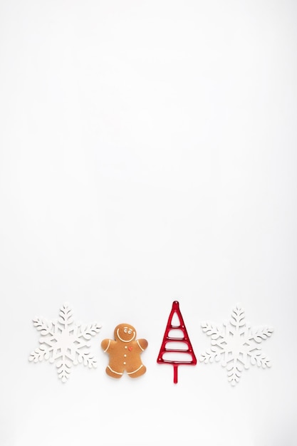 Christmas composition made of snowflakes gingerbread man cookies on white background. Winter holidays concept. Flat lay, top view, copy space