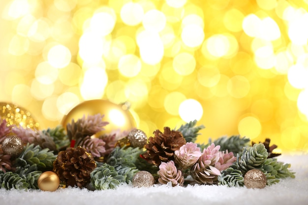 Christmas composition with baubles and fir-tree on snow on bright background