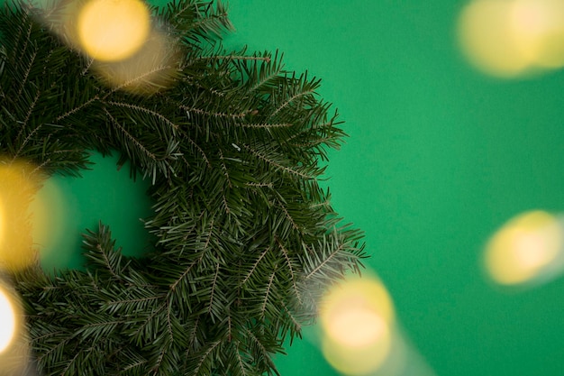 Christmas composition with Christmas ring or wreath and glowing garland on the green background Copy space