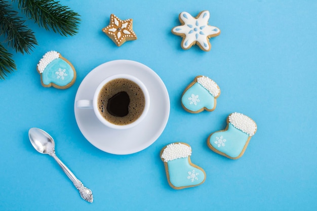 Christmas composition with coffee cup and gingerbread on the blue background Top view Copy space