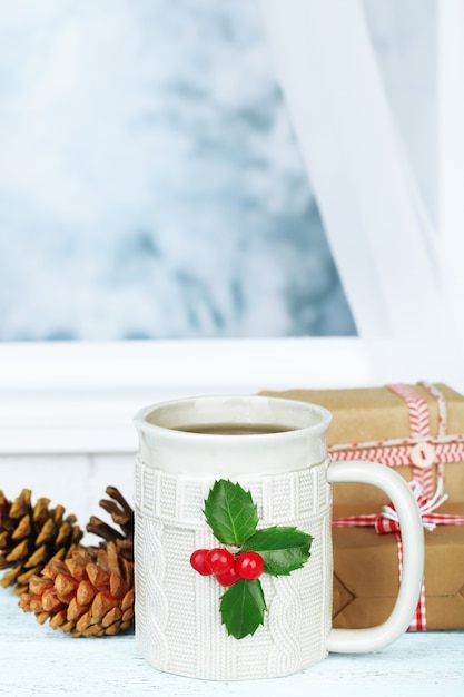 Christmas composition with cup of drink, on wooden table