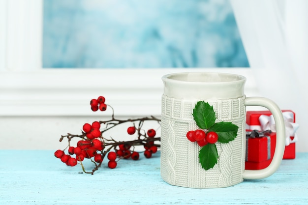 Christmas composition with cup of hot drink, on wooden table