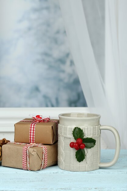 Christmas composition with cup of hot drink, on wooden table