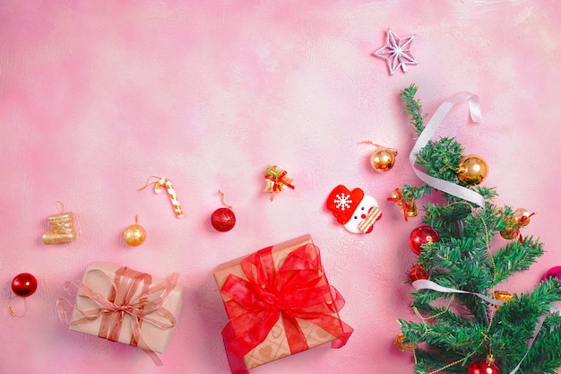 Christmas composition with decorations and gift box with bows on pink pastel background. winter, new year concept. Flat lay, top view, copy space.