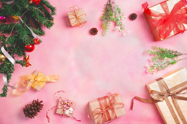 Christmas composition with decorations and gift box with bows on pink pastel background. winter, new year concept. Flat lay, top view, copy space.