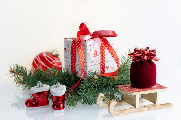 Christmas composition with decorations, gift boxes, baubles, boots and sleigh of Santa Claus. on white . Christmas holidays  with copyspace .