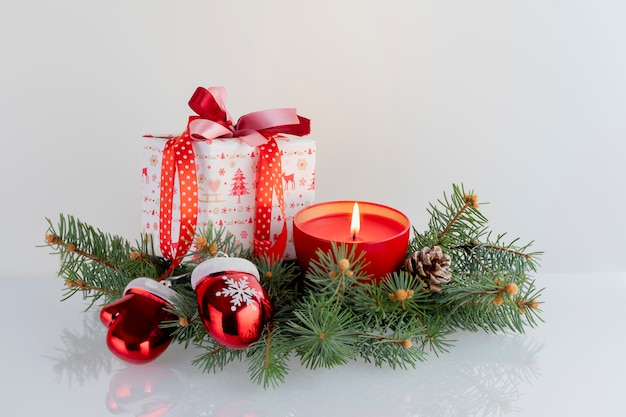 Christmas composition with decorations, gift boxes, red candle, gauntlets of Santa Claus and baubles on white . Christmas holidays  with copyspace .