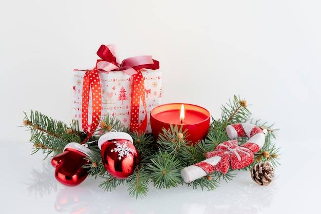 Christmas composition with decorations, gift boxes, red candle, gauntlets of Santa Claus and baubles on white . Christmas holidays  with copyspace .