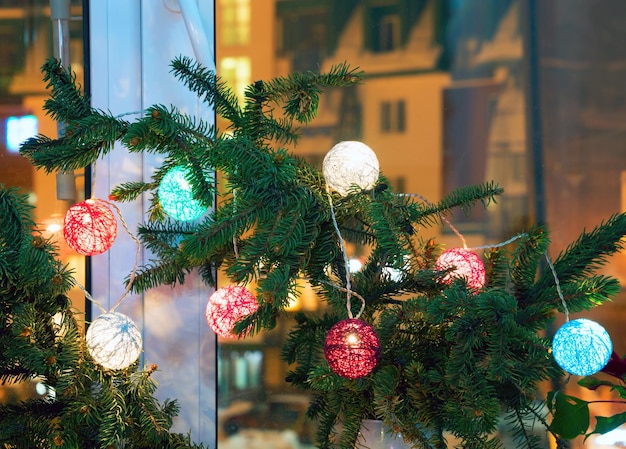 Christmas composition with fir branches and lanterns on the windowsill