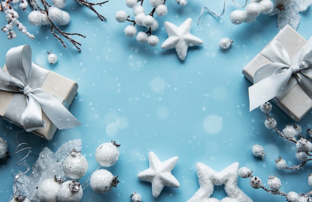 Christmas composition with frame made of white decoration on pastel blue surface