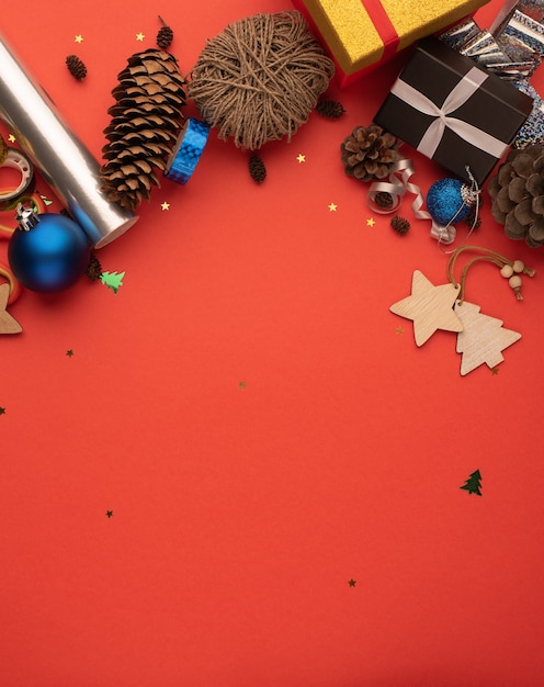 Christmas composition with gift boxes cones and decoration on a red background