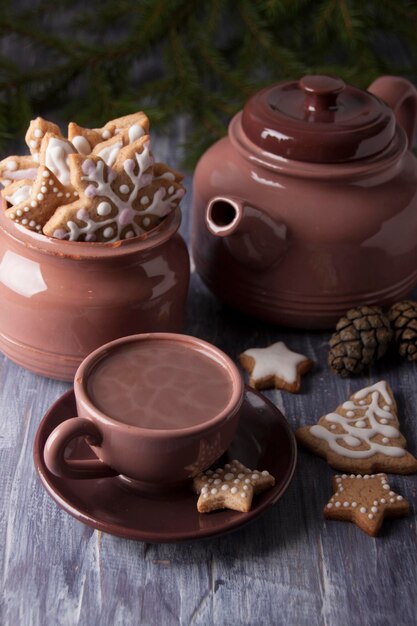 Christmas composition with ginger cookies and a cup of cocoa on the background of spruce branches