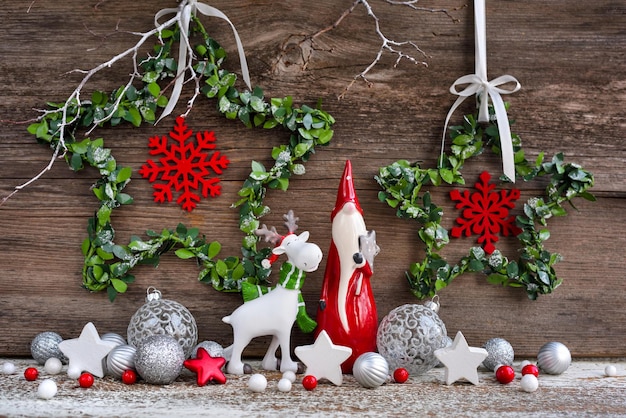 Photo christmas composition with gnome elk figurine and festive decorations on wooden background