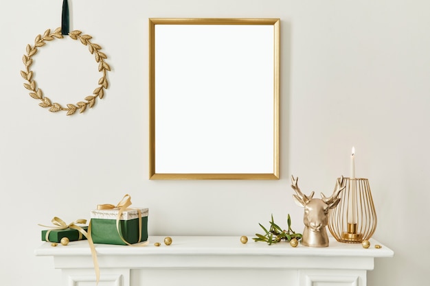 Christmas composition with gold mock up poster frame, white chimney and decoration. Christmas trees and wreath, candles, stars, light and elegant accessories. Template.