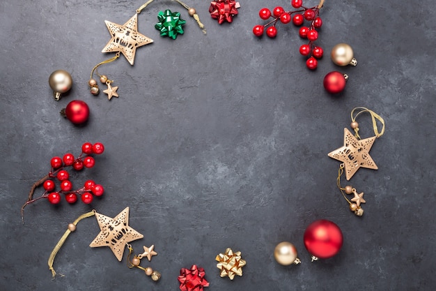 Christmas composition with gold and red decoration on dark stone background. Top view Copy space - Image