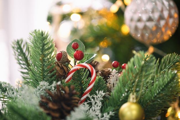 Christmas composition with pine leaves, pine cones, holly balls, candy cane and ball