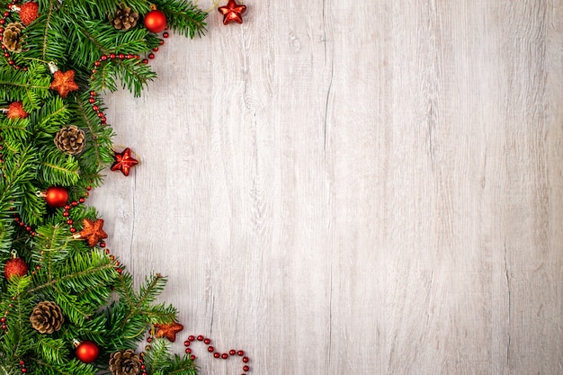 Christmas composition on wood  for your winter holidays greetings. Christmas red balls and stars, pine cones, red string on a textured wood .