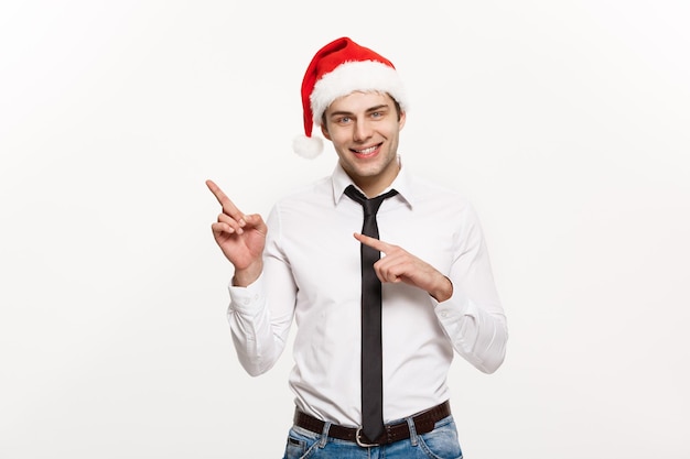 Christmas Concept Handsome Business man wear santa hat pointing finger on side with white isolated background