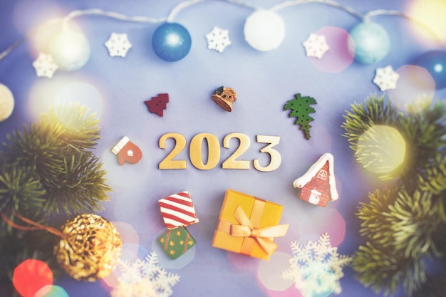 Christmas concept New Year 2023 gifts Copy space framed by Christmas tree branches decorations sweets