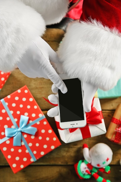 Christmas concept. Santa with smart phone in hands close up