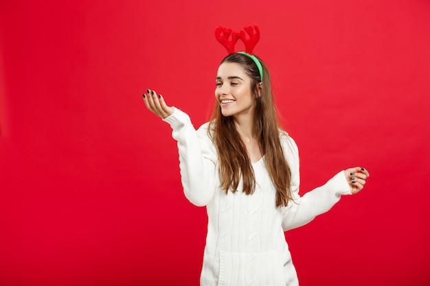 Christmas Concept - Young attractive caucasian lady wear reindeer hairband celebrating in Christmas day.