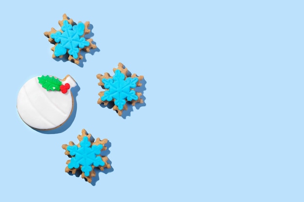 Christmas cookies shape of ball and snowflakes form on the blue background top view flat lay copy space