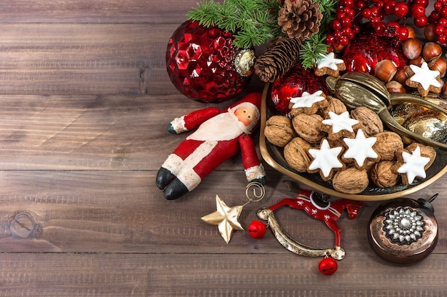 Christmas cookies and walnuts with vintage decorations on wooden background