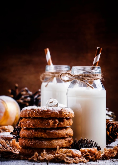 Christmas cookies and warm milk in bottles rustic style vintage wood background selective focus