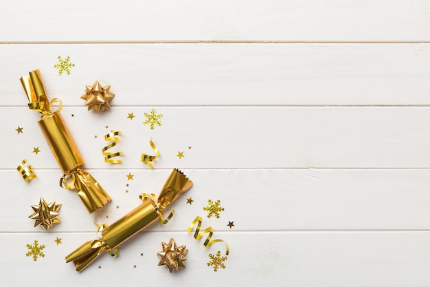 Christmas crackers with shiny confetti on color background, top view, copy space