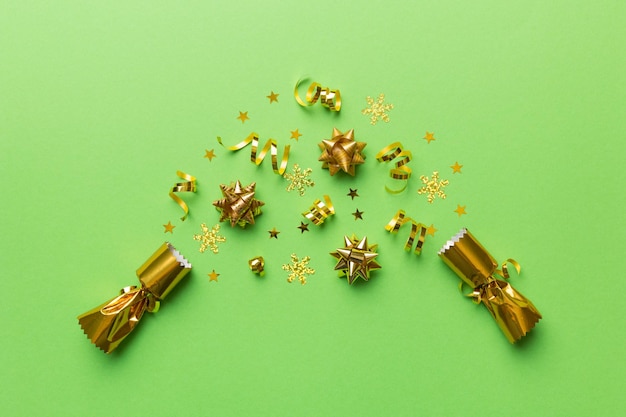 Christmas crackers with shiny confetti on color background, top view, copy space