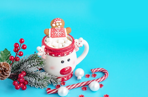 Christmas Cup of hot chocolate with marshmallow and gingerbread man on a blue background Creative concept of New year and Christmas