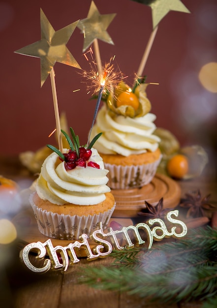 Christmas cupcakes with vanilla frosting, cranberries and rosemary