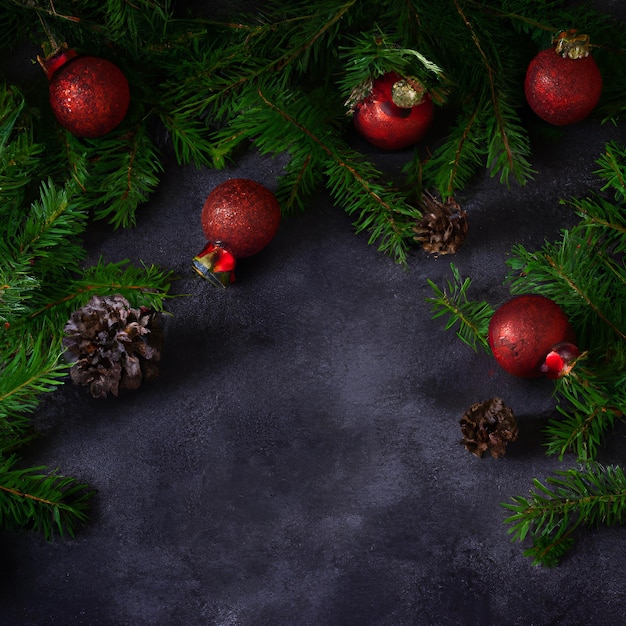 christmas deco with fir and baubles on dark background. flat lay. Christmas concept