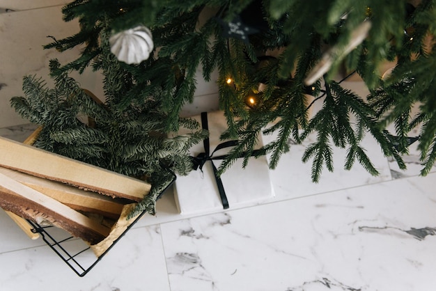 Christmas decor beautifully packaged gifts under the Christmas tree with firewood for the fireplace