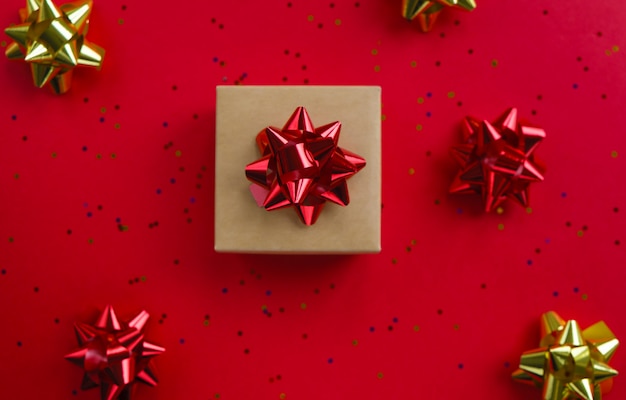 Christmas decor on a red. Sequins and a bow for gifts. Christmas flatlay. 